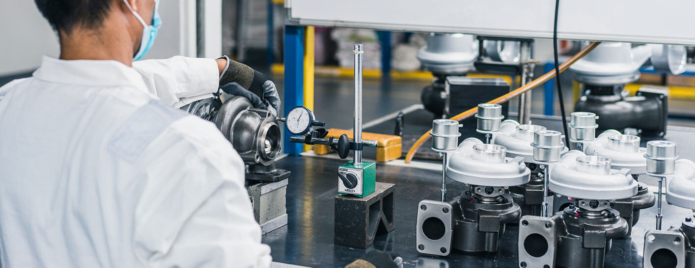 Teknisi memeriksa komponen turbocharger berkualitas di fasilitas manufaktur turbocharger